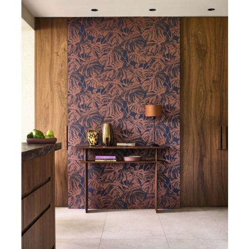 Nagyvonalú stilizált Monstera levélmotívum lágyan megcsillanó fémes részletekkel tintakék cseresznye bronzos vörösesbarna tónus tapéta